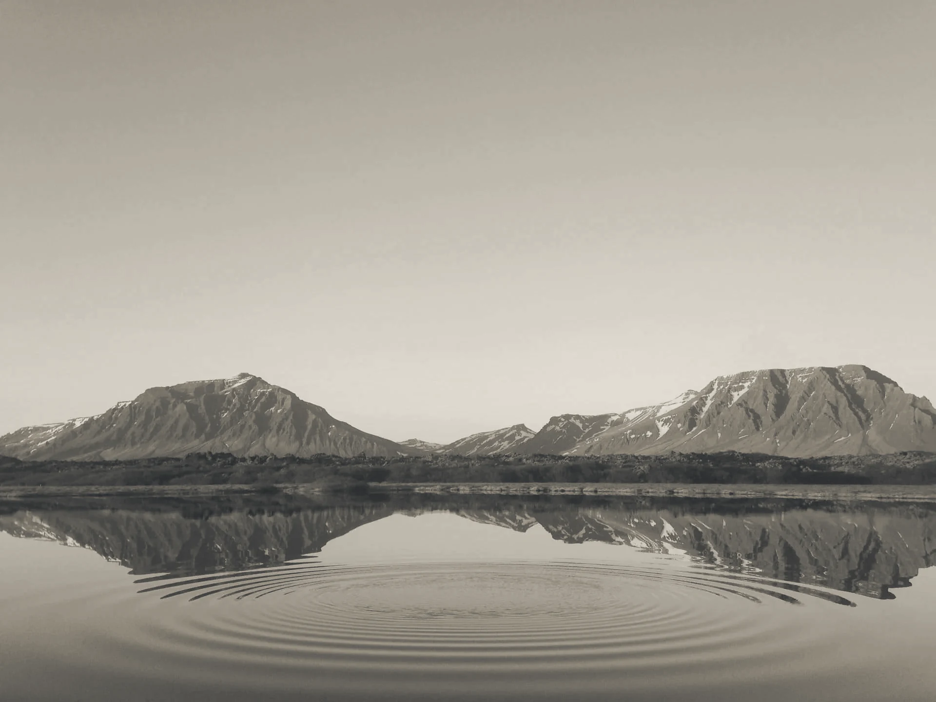 Verschneite Berge spiegeln sich in einem ruhigen See