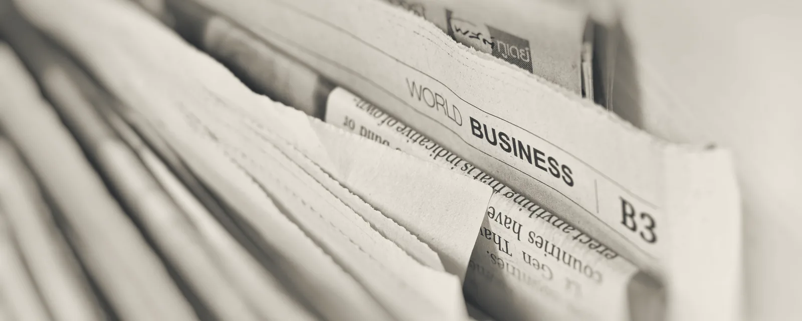 Gestapelte Zeitungen, eine davon mit der Rubrik World Business