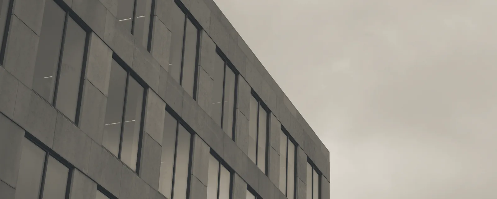 Moderne Bürofassade aus Glas und Stein als Sinnbild für regulatorische Stabilität