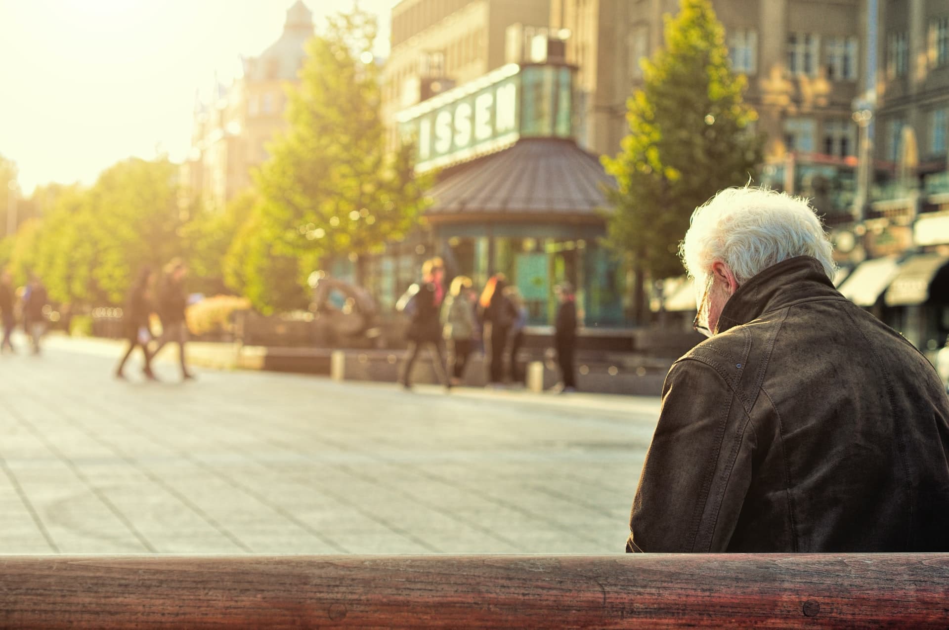 Old person sitting in the city street